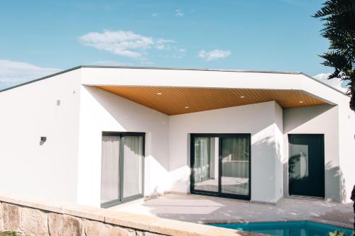 a white house with a pool in front of it at Casa da Tininha in Couto