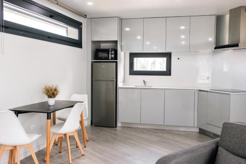 a kitchen with white cabinets and a table and chairs at Casa da Tininha in Couto