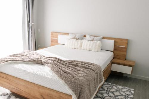a bedroom with a wooden bed with white sheets and pillows at Casa da Tininha in Couto