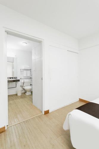 a white room with a bed and a bathroom at Wyndham Costa del Sol Chiclayo in Chiclayo