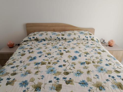 a bed with a bedspread with blue flowers on it at Myriamare in Manfredonia