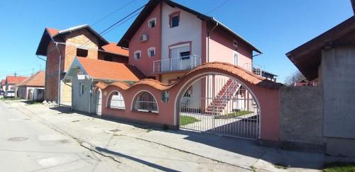 a red building with an archway on a street at Konak Kod Gorana 3 in Subotica