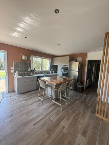 une cuisine avec une table et des chaises dans une pièce dans l'établissement Les Oliviers, à Fort-Mahon-Plage