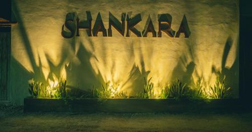 a sign on the side of a building with plants at Shankara Holbox in Holbox Island