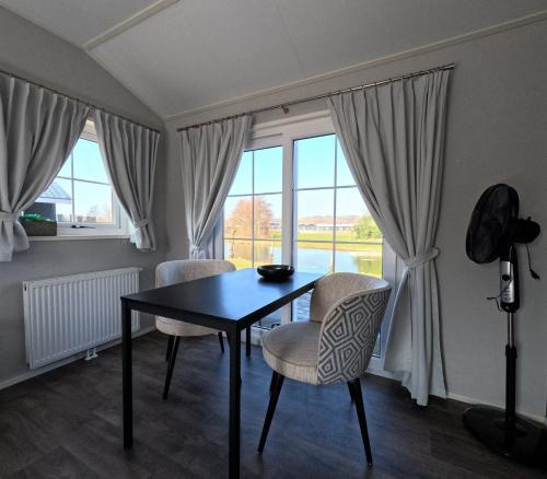 a dining room with a table and chairs and a window at Resort Land & Zee in Scharendijke