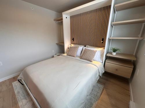Un pequeño dormitorio con una cama blanca y estanterías en DWELL in Alaska "BIG" Unit i, en Fairbanks