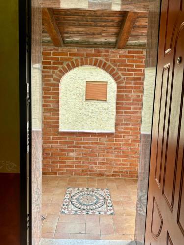 an entrance to a brick wall with a window at VilaHasa in Tërbuf
