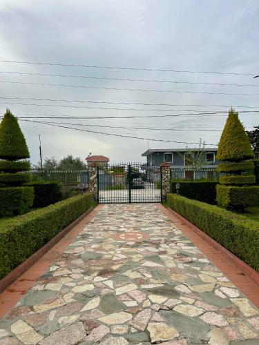 a gate in a garden with a stone walkway at VilaHasa in Tërbuf