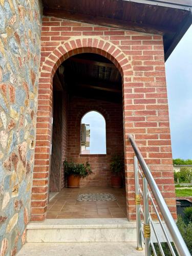 an entrance to a brick building with an arch at VilaHasa in Tërbuf
