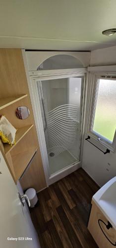 - une petite salle de bains pourvue d'une douche en verre dans l'établissement Oasis évasion méditerranéenne, à Puget-sur Argens