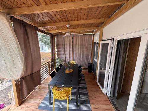 a patio with a table and chairs on a deck at Ventura mobile home in Biograd na Moru