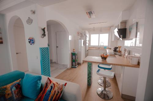 a kitchen and living room with a couch and a counter at Casa Melina in Cala del Moral