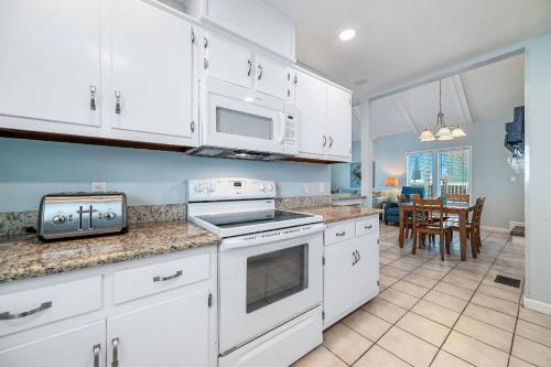 a kitchen with white appliances and a dining room at Paradise Duplex A in Gulf Shores