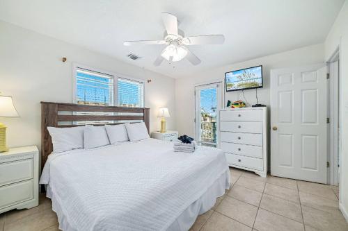a bedroom with a white bed and a ceiling fan at Paradise Duplex A in Gulf Shores