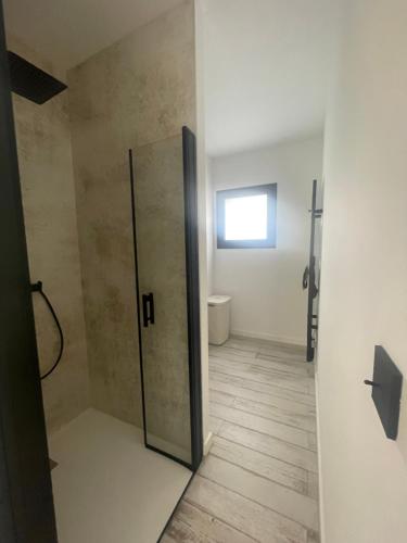 un bagno con doccia con porta in vetro di La Villa des Chênes ad Audenge