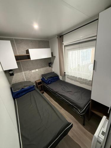 une chambre avec deux lits superposés et une fenêtre dans l'établissement CAMPING BONNE ANSE PLAGE, à La Palmyre