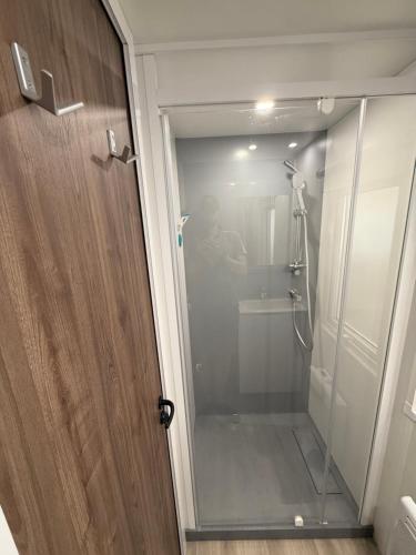 une douche avec une porte vitrée dans une salle de bain dans l'établissement CAMPING BONNE ANSE PLAGE, à La Palmyre