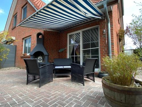 d'une terrasse avec des chaises, une table et une cheminée. dans l'établissement Garten, Terrasse und Kamin - Cozy Cottage 1, à Burg