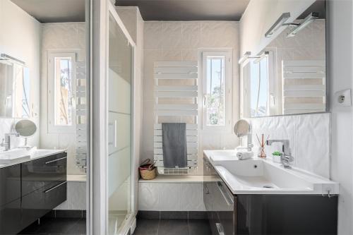 une salle de bain blanche avec deux lavabos et une douche dans l'établissement New Moon, à La Ciotat