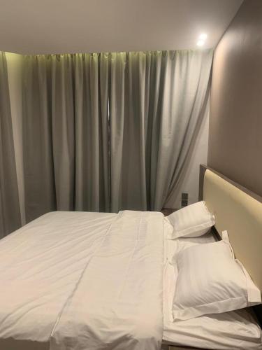 a bedroom with a white bed with a window at اعالي للشقق المخدومه in Abha