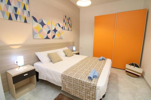 a bedroom with a bed and a orange cabinet at Farri's Apartment in La Caletta