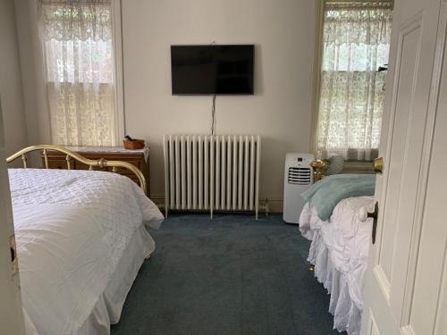 a bedroom with two beds and a flat screen tv at Susquehanna Manor Inn in Marietta