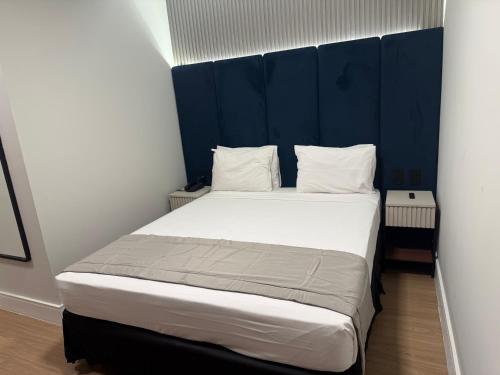 a bedroom with a large bed with a blue headboard at Américas Benidorm Hotel in Rio de Janeiro