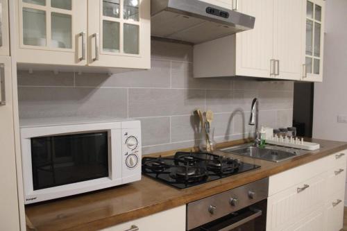 a kitchen with a microwave and a stove at La finestra sul Farfa in Bocchignano