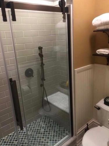 a shower with a glass door in a bathroom at Susquehanna Manor Inn in Marietta