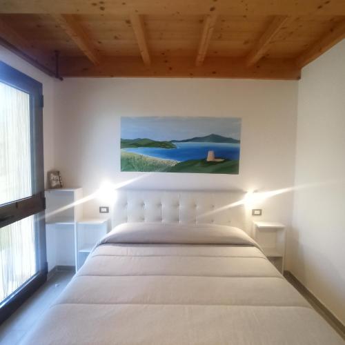 a bedroom with a bed and a painting on the wall at Agriturismo La tana della volpe in Alberese