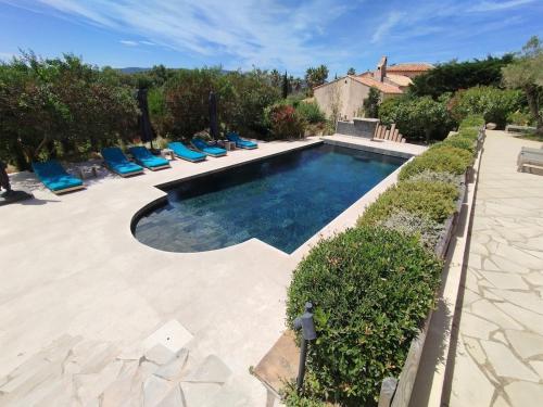 - une piscine avec des chaises longues bleues dans la cour dans l'établissement Villa MagnifiK I Luxe I Pool I Sea View I Clim, à Grimaud