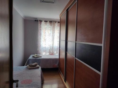 a small room with a bed and a window at piso avda sabinal con piscina in Roquetas de Mar
