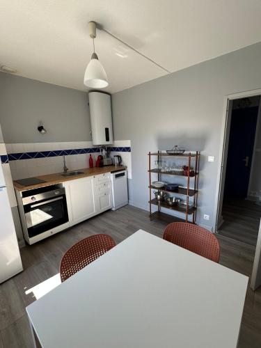 une cuisine avec une table et des chaises dans une pièce dans l'établissement Appartement cosy avec vue sur les montagnes, à Saint-Nabord