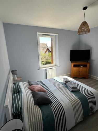 une chambre avec un grand lit et une fenêtre dans l'établissement Appartement cosy avec vue sur les montagnes, à Saint-Nabord