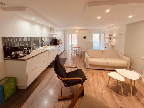 une cuisine et un salon avec un canapé et une table dans l'établissement Duplex 3 couchages séparés Clim Wifi proche du port et commerces, à Port-Vendres