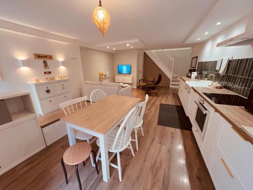 une cuisine et une salle à manger avec une table et des chaises en bois dans l'établissement Duplex 3 couchages séparés Clim Wifi proche du port et commerces, à Port-Vendres