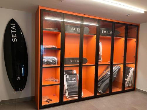 a glass display case with a surfboard in it at Frente Mar de Cabo Branco - Setai Edition in João Pessoa