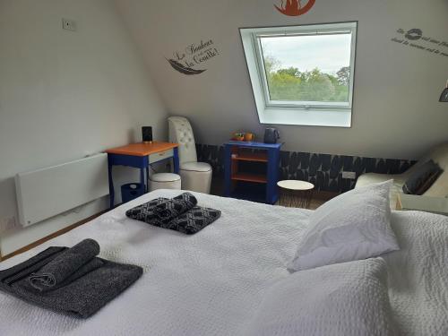 a bedroom with a bed with two towels on it at Chambre et table d'Hotes Manava Loretta in Bannalec