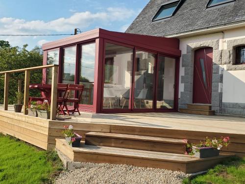 a screened in porch with a table on a deck at Chambre et table d'Hotes Manava Loretta in Bannalec