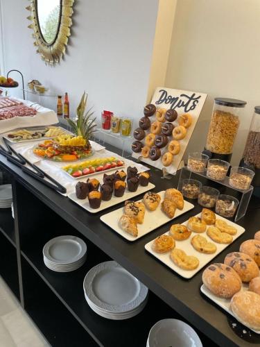 a buffet filled with different types of pastries and donuts at Adriano Boutique Sevilla in Seville