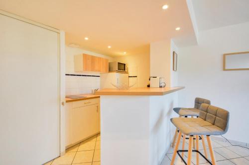une cuisine avec deux tabourets de bar et un comptoir dans l'établissement La tanière à la porte verte - Les Cosy by RockinShare, à Nancy