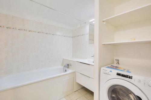 une buanderie blanche avec un lave-linge. dans l'établissement La tanière à la porte verte - Les Cosy by RockinShare, à Nancy