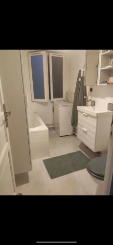 une salle de bain blanche avec un lavabo et des toilettes dans l'établissement Charming apartment in the center of Paris (SSD), à Paris