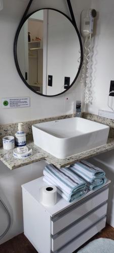 a bathroom with a white sink and a mirror at Chalé de alto padrão em condomínio in Santa Rita do Sapucaí