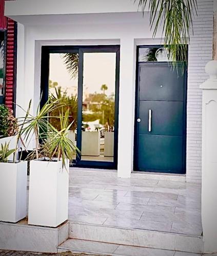 a blue front door of a house with potted plants at Vera Holydays in Torremolinos
