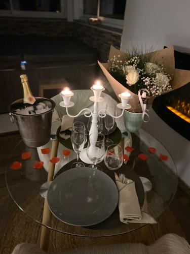 a glass table with wine glasses and candles on it at Hygge Roquetoire in Roquetoire