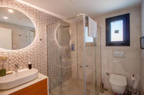 een badkamer met douche, wastafel en spiegel bij Villa Casa Luz 2 in Bodrum City