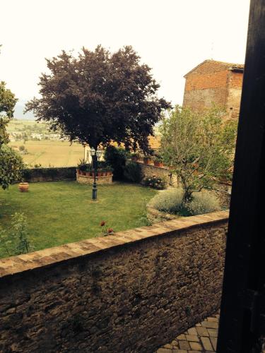 a view of a garden with a tree and a wall at Tre Girasoli in Monte San Savino