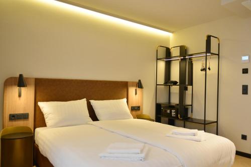 a bedroom with a large bed with white sheets at Day8 Hotel in Cologne