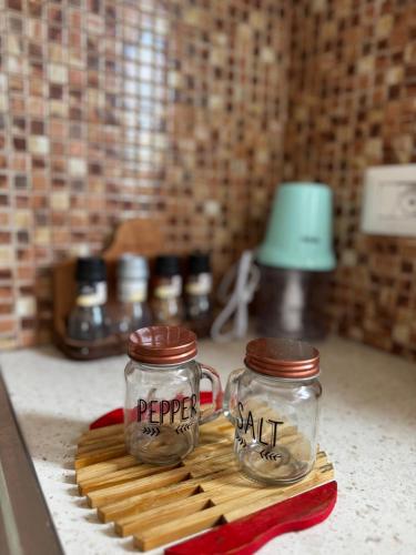 two glass jars on a cutting board on a kitchen counter at Raffaello's Villa in Vlorë